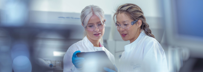 Researchers looking over tablet of data